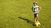 Little boy with a plastic football on the grass