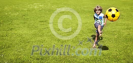 Boy kicking a ball on the field