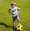 Boy standing with one leg on a football