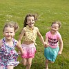 Three girls running on the grass