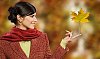 Woman holding a maple leaf on the tip of her finger