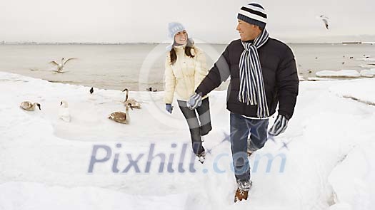 Couple walking on the beach in winter