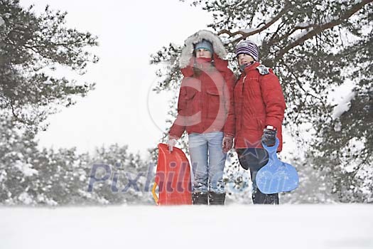 Girls with sledges on a snowy day