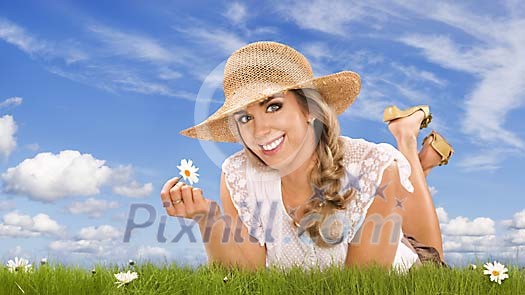 Woman on the grass holding a daisy