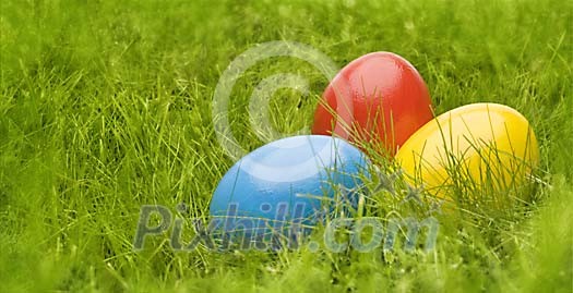 Three painted eggs in the grass