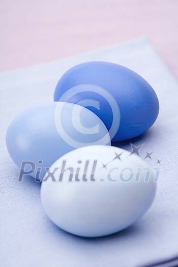 Three blue coloured eggs on the table