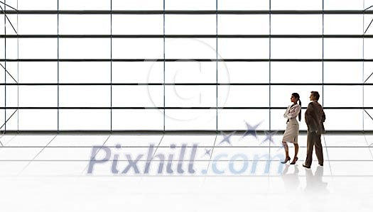Man and woman standing next to a huge wall of glass