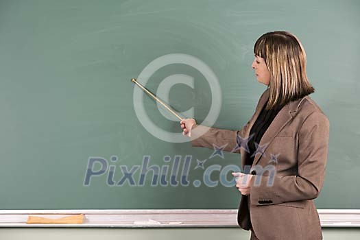 Female teacher pointing to blackboard