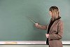 Female teacher pointing to blackboard
