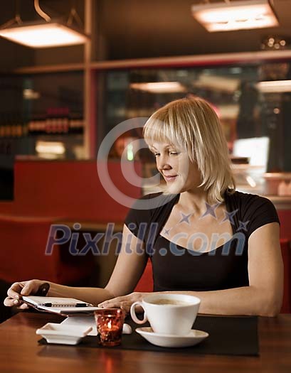Woman in cafeteria with calendar and cup of coffee