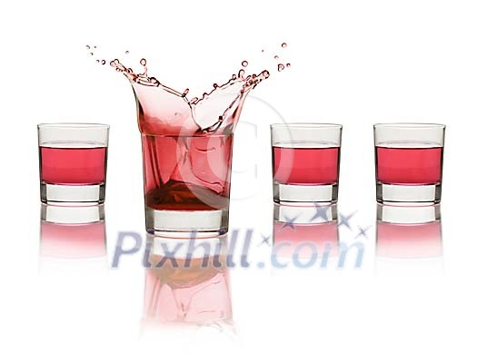 Four red drinks, one splashing Four red drinks, one splashing