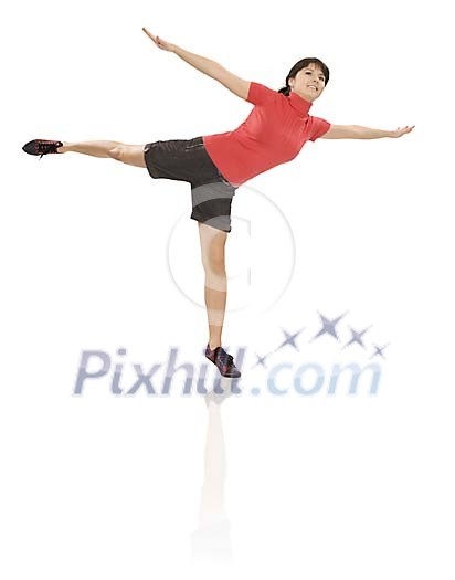 Woman balancing on one foot in white