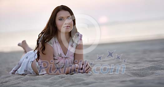 Young woman lying on the beach in sunset