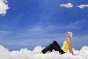 Young woman sitting on clouds