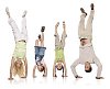 Mom, two daughters and dad doing handstand in white space