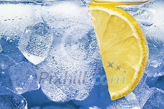 Close-up of lemon slice in water with ice Close-up of lemon slice in water with ice