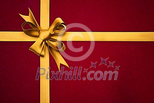 Close-up of a golden ribbon on a red package Close-up of a golden ribbon on a red package