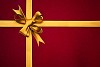 Close-up of a golden ribbon on a red package