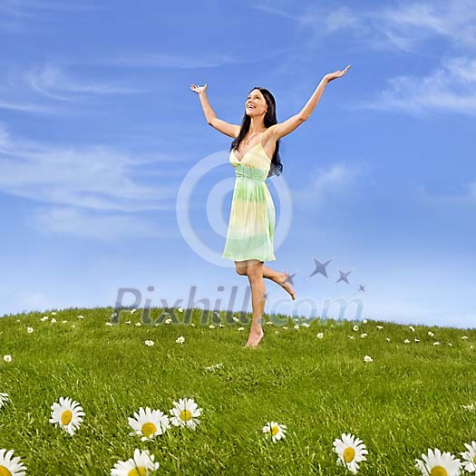 Beautiful girl walking in a meadow of grass and daisies