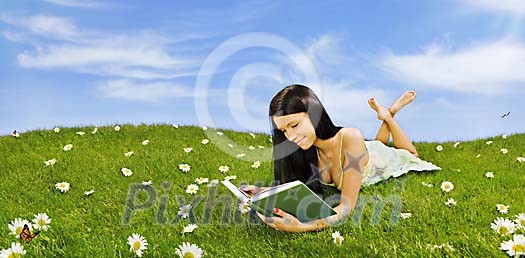 Girl reading book in a meadow