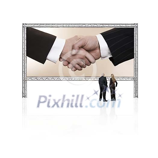 Two business persons in front of a giant display with shaking hands