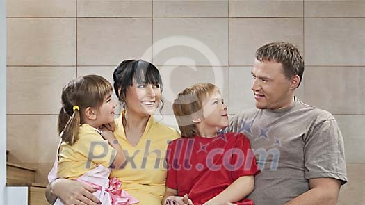 Family of four against grey tile wall