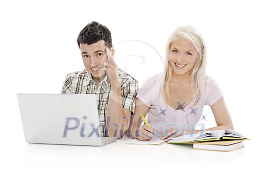 Teenage boy and girl behind study books and laptop