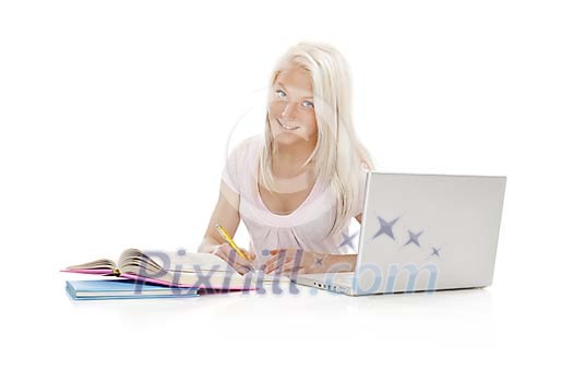Teenage girl behind study books and laptop
