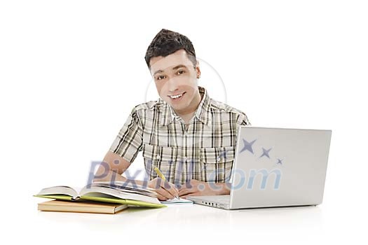 Teenage boy behind study books and laptop