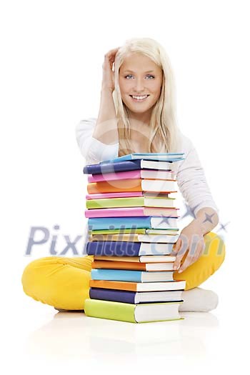 Teenage girl sitting behind a pile of books