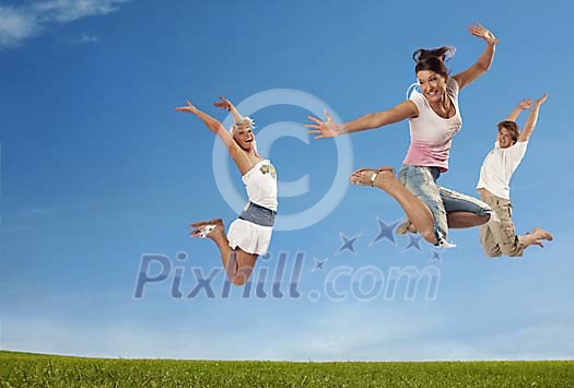 Young adults jumping on grass