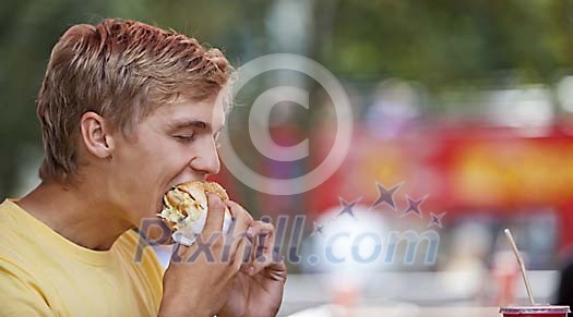 Young man eating a hamburger