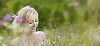 Bautiful woman in meadow surrounded by blurred meadow flowers