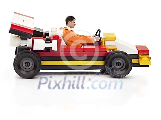 Adult man driving a toy race-car Adult man driving a toy race-car