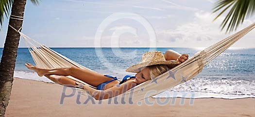 Woman on the beach lying on the hammock