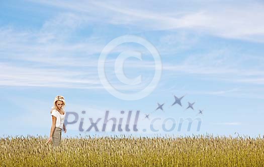 Beautiful woman walking alone in a summery field