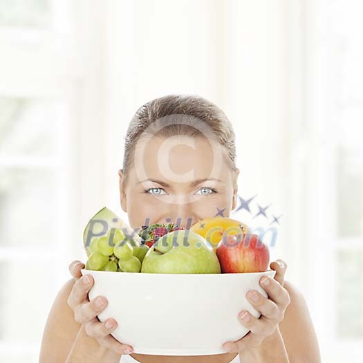 Woman holding a bowl full of fruits