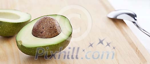 Half of avocado on a cutting board Half of avocado on a cutting board