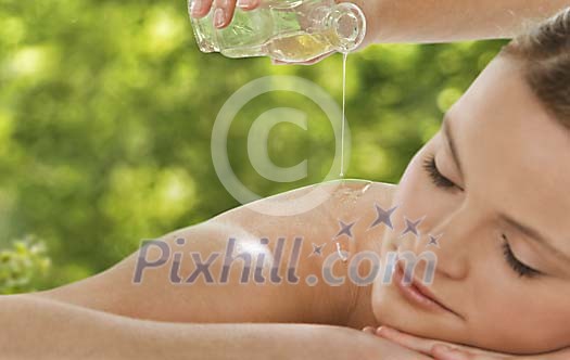 Pouring oil on a womans shoulder