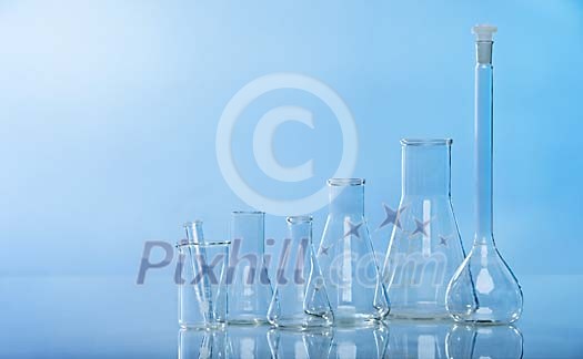 Empty measuring glasses on a blue background
