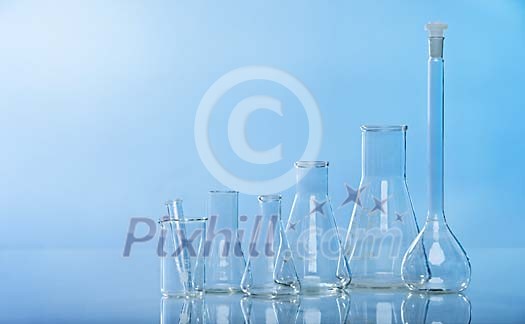 Empty measuring glasses on a blue background Empty measuring glasses on a blue background