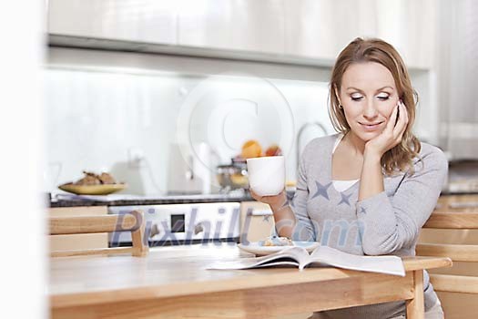 Woman sitting at the kitchen table reading