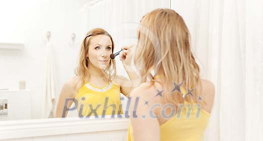 Woman putting rouge on her face Woman putting rouge on her face