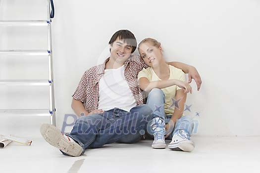 Couple sitting on the floor next to a ladder Couple sitting on the floor next to a ladder