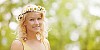 Beautiful girl wearing a summer wreath made of fresh daisies