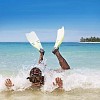 Man in small waves on the beach with snorkeling equipment