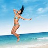 Woman jumping in the air with sea at the background