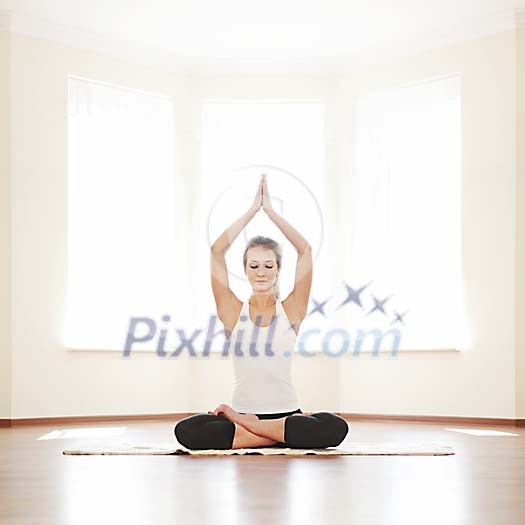 Woman meditating with hands above her head