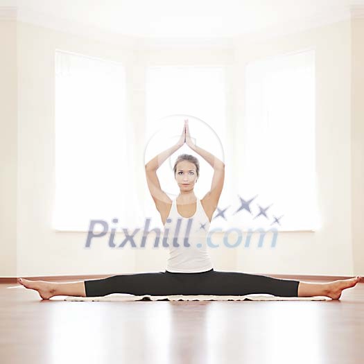 Woman doing splits with hands above her head