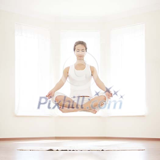 Woman meditating and hovering above the floor